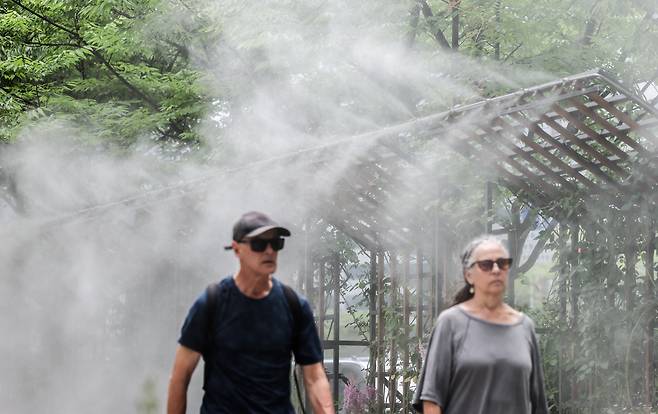 서울 전역에 폭염주의보가 내려진 지난 30일, 외국인 관광객들이 서울시청 앞 광장에 설치된 쿨링포그 사이를 지나가고 있다. / 고운호 기자