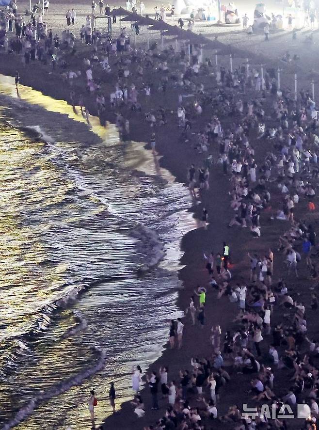 올 여름 부산지역에 지난해보다도 19일나 빨리 열대야가 찾아온 가운데 부산 광안리해수욕장을 찾은 시민과 관광객들이 더위를 식히고 있다. 뉴시스 제공