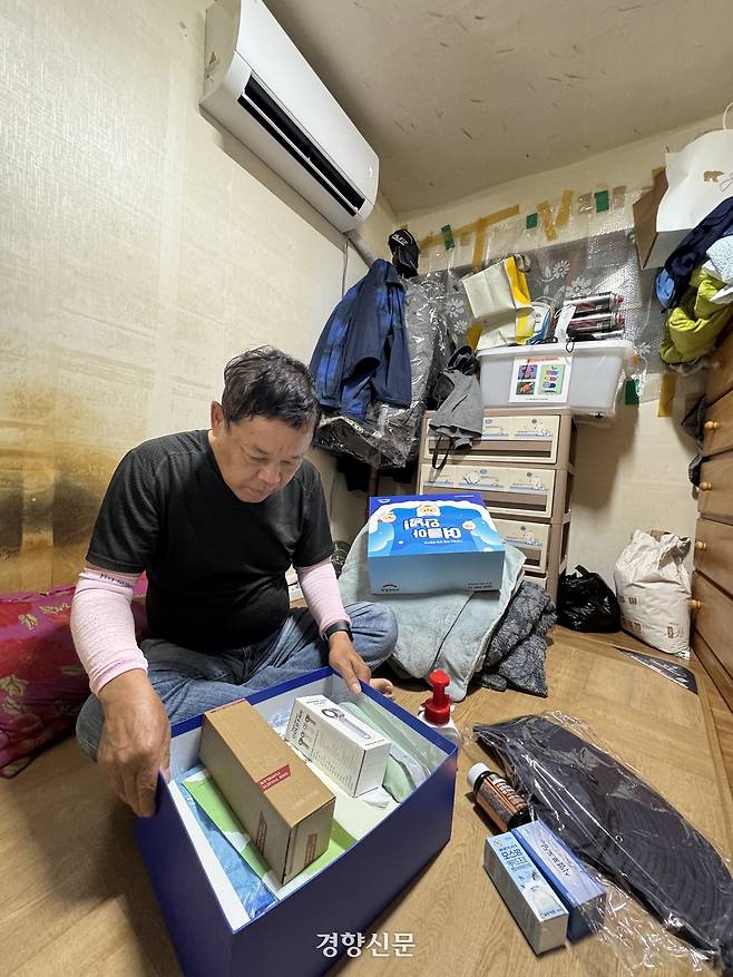 대구 중구 한 쪽방에서 주민 이윤덕씨가 지난 19일 민간 구호단체가 폭염 대응 지원 등을 위해 보낸 물품을 들여다보고 있다. 이씨의 방에는 지난해 대구시 지원으로 에어컨이 설치돼 있다. 하지만 이씨처럼 지원을 받기 위해서는 집 주인의 동의와 설치 가능 기준 등의 조건을 충족해야 한다. 백경열 기자