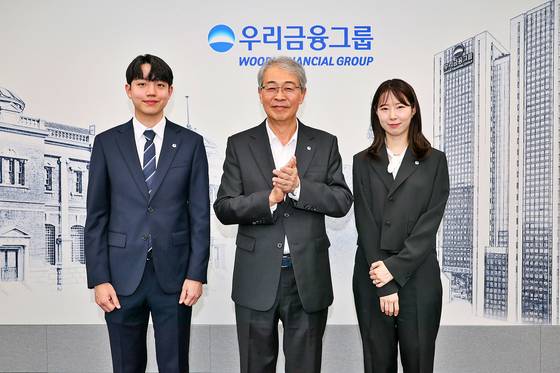 Woori Financial Group chairman Yim Jong-ryong, center, poses for the camera with employees of Tongyang Life Insurance and ABL Life Insurance. [WOORI FINANCIAL GROUP]