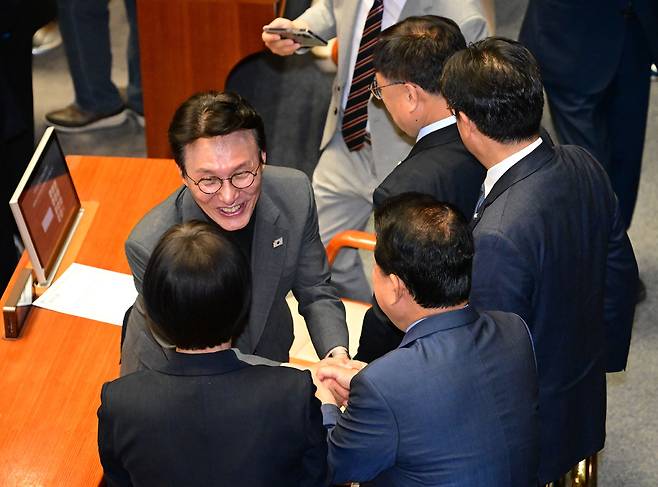 김민석 국무총리 후보자가 지난달 26일 국회에서 열린 본회의에서 더불어민주당 의원들과 인사하고 있다.&nbsp; &nbsp;국회사진기자단