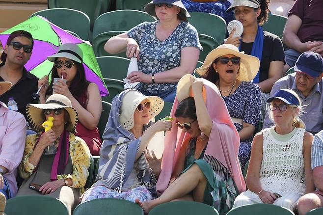 윔블던 테니스 대회를 관전하는 팬들이 더위를 식히고 있다. AP