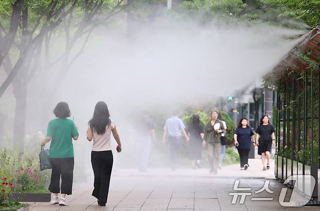 무더위가 이어지는 3일 오후 시민들이 서울광장에 설치된 쿨링포그 앞을 지나며 더위를 식히고 있다. 2025.7.3/뉴스1 ⓒ News1 구윤성 기자