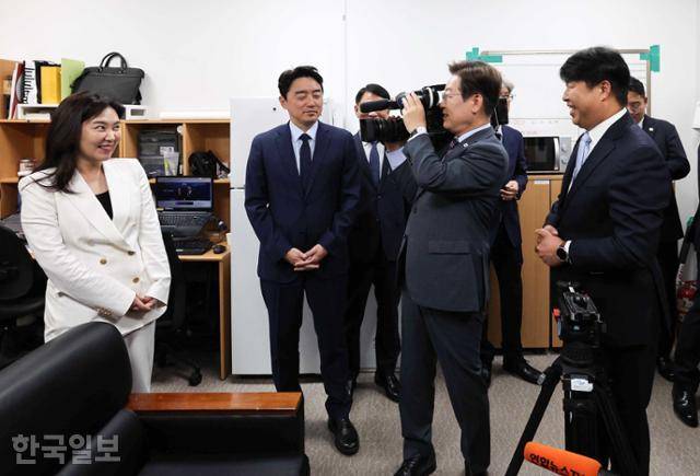 이재명 대통령이 지난달 12일 용산 대통령실 영상기자실을 방문해 카메라를 어깨에 메고 뷰파인더를 보고 있다. 왼쪽은 강유정 대변인. 왕태석 선임기자