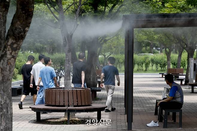 서울의 한낮 체감온도가 33도까지 오르는 등 무더위가 이어지고 있는 지난 1일 서울 여의도공원에서 시민들이 쿨링포그 벤치에 앉아 더위를 피하고 있다. 문재원 기자