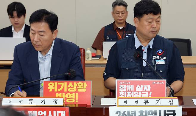 최저임금위원회 사용자위원인 류기정 한국경영자총협회 전무(왼쪽)와 근로자위원 류기섭 한국노총 사무총장이 3일 정부세종청사에서 열린 최저임금위원회 제9차 전원회의에서 나란히 자리하고 있다. [사진 = 연합뉴스]