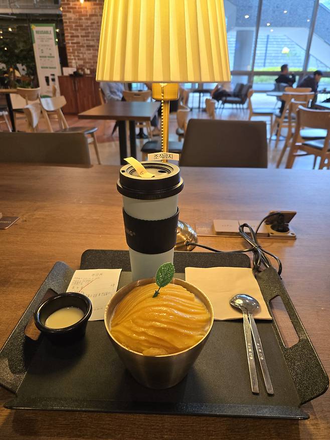 ㅋㅋ다방에서 받아 든 망고빙수와 '거먹구름' 커피. 다방 내부는 노란색 조명과 갈색 배경으로 포근하다./사진=이찬종 기자
