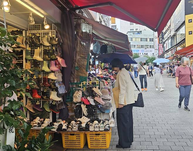 2일 오전 서울 중구 남대문시장에 한 시민이 레인부츠와 샌들을 구경하고 있다./사진=박상혁 기자.