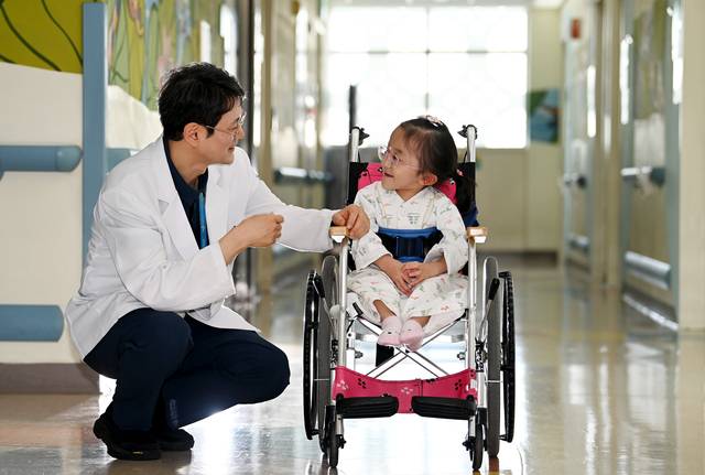 지난달 23일 경남 양산시 물금읍 범어리 부산대어린이병원 6층 63병동 복도에서 전종근(왼쪽) 부산대의대 의학유전학과 교수가 희귀질환인 ‘골형성 부전증’을 앓는 어린이와 다정하게 대화를 나누고 있다.  윤성호 기자