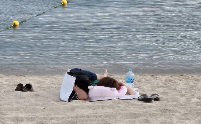 초열대야를 피해 3일 새벽 경포해변으로 나와 잠을 자는 부부 [촬영 유형재]