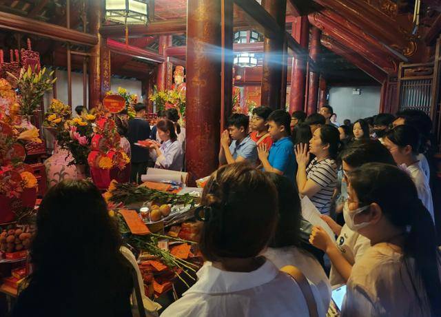 지난달 23일 베트남 하노이 문묘에서 전국 고등학교 졸업시험을 앞둔 수험생과 학부모들이 좋은 성적을 기원하며 기도하고 있다. 제단에는 꽃과 과일, 과자 등 이들이 준비한 제물이 잔뜩 놓여 있다. 하노이=허경주 특파원