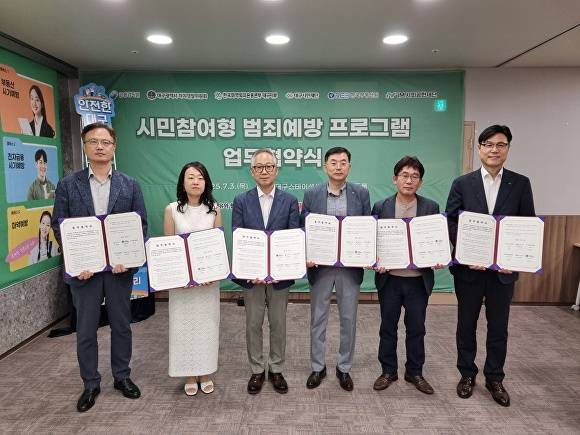 시민참여형 범죄예방 프로그램 운영을 위한 업무협약 참석자들이 협약서를 들어보이고 있다 [사진=대구시]