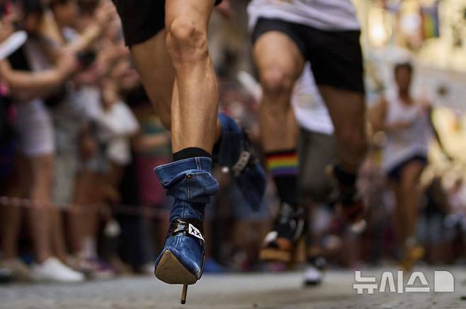 [마드리드=AP/뉴시스] 3일(현지 시간) 스페인 마드리드에서 열린 '마드리드 프라이드 주간의 연례 하이힐 레이스'에 참가한 참가자들이 높이 15cm의 하이힐을 신고 달리고 있다. 2025.07.04.