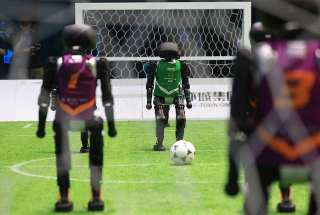 6월 28일 중국 베이징에서 열린 휴머노이드 로봇 축구 경기에서 중국 농업대학의 산악해 팀 로봇이 경기에 나서고 있다. 신화연합