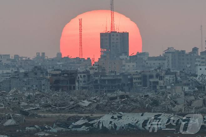 이스라엘 공습으로 폐허가 된 가자지구 너머로 해가 지고 있다. 2025.07.02. ⓒ 로이터=뉴스1 ⓒ News1 이지예 객원기자