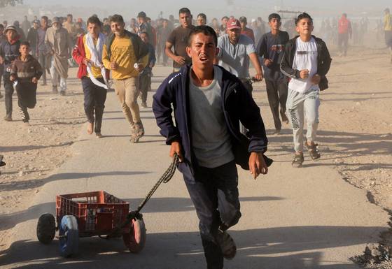 구호물자를 받기 위해 가자인도주의재단(GHF) 배급소로 달려가는 팔레스타인 주민들. 로이터=연합뉴스