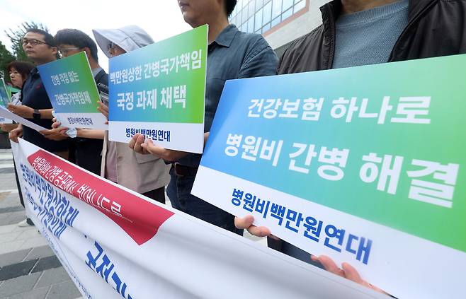 지난 1일 서울 종로구 정부서울청사 창성동 별관 앞에서 ‘어린이부터 어르신까지 병원비백만원연대’가 이재명정부에&nbsp;간병 국가 책임제와&nbsp;병원비 100만원 상한제 시행을 촉구하고 있다. 뉴시스