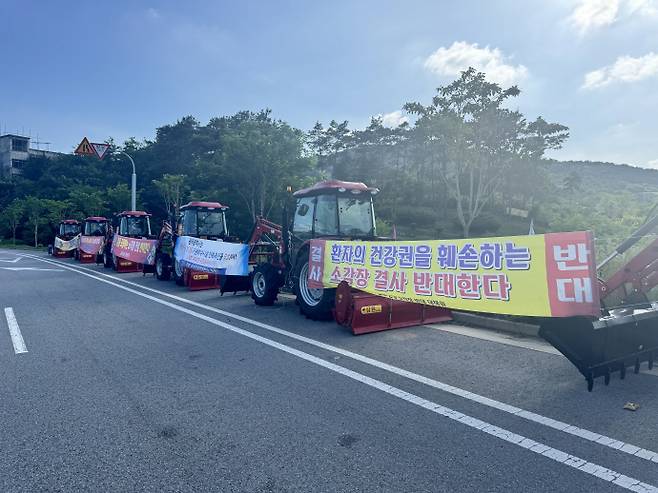 6일 오전 광주 광산구 삼거동. 도로 한켠에 빨간 트랙터 10여 대가 줄지어 서있다. 차량마다 '의혹투성이 소각장 결사 반대', '주민 동의 없는 소각장 반대' 등이 적힌 현수막과 깃발이 걸려 있었다. /임지섭 기자 ljs@namdonews.com