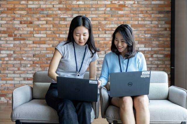 CFDP를 통해 쿠팡에 입사한 구현지 씨(왼쪽)와 조한나 씨가 사내 라운지에서 노트북을 보며 업무에 대해 의견을 나누고 있다