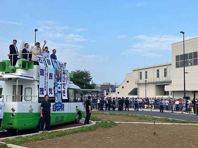 이시바 시게루 총리가 5일 일본 사이타마현 나나사토역 앞 유세 차량 위에서 마이크를 들고 지원 유세를 하고 있다. 삼엄한 경비 속에 청중과의 거리가 멀리 떨어져 있다. 출처 이시바 시게루 총리 ‘X’