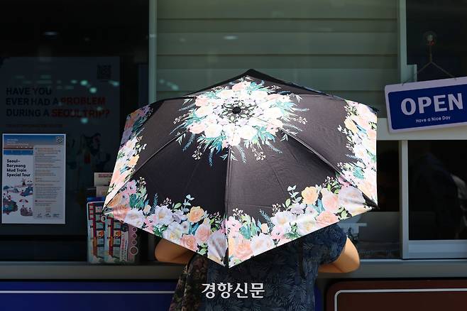 전국적으로 무더운 날씨를 보인 지난 6월23일 서울 중구 남대문시장을 찾은 시민이 양산을 쓰고 있다. 정효진 기자