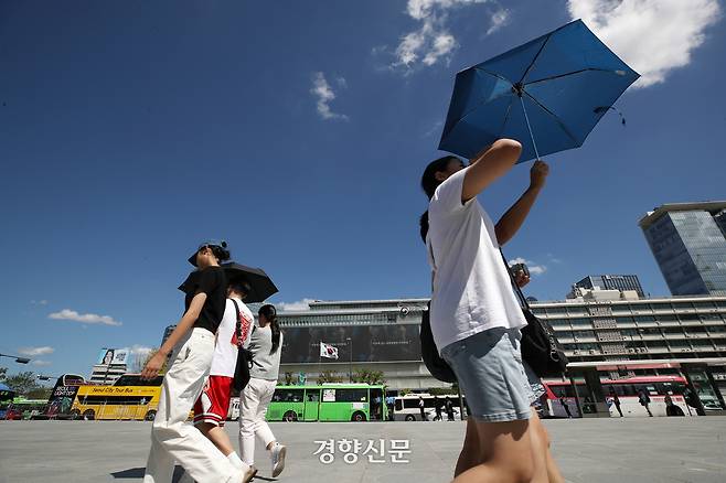 양산을 쓴 시민이 지난해 8월30일 서울 종로구 광화문광장 인근을 걸어가고 있다.  권도현 기자