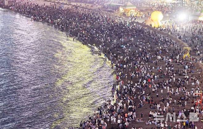 [부산=뉴시스] 하경민 기자 = 폭염특보와 열대야 현상으로 인해 밤낮으로 푹푹 찌는 더위가 이어진 5일 밤 부산 수영구 광안리해수욕장에서 시민과 관광객들이 더위를 식히고 있다. 2025.07.06. yulnetphoto@newsis.com