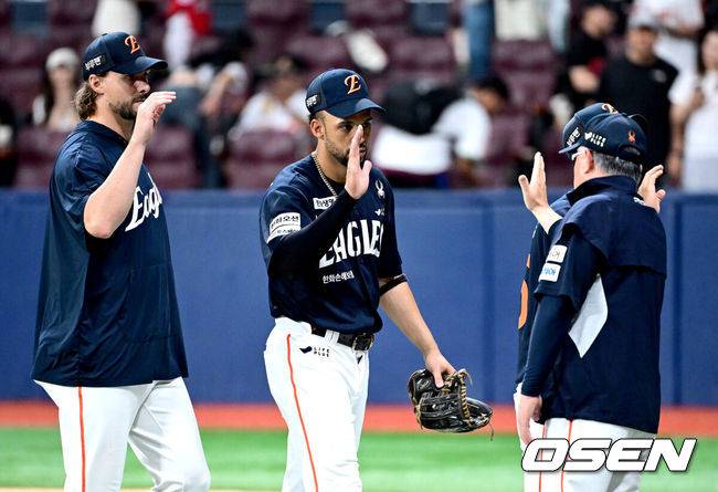 [OSEN=고척, 최규한 기자] 프로야구 한화 이글스가 전반기 마지막 주말 3연전을 모두 쓸어담으며 전반기 1위를 확정했다.&nbsp;한화는 6일 서울 고척스카이돔에서 열린 ‘2025 신한은행 SOL Bank KBO리그’ 키움 히어로즈와의 경기에서 10-1로 승리했다. 이날 승리로 3연승을 달리며 시리즈 스윕에 성공한 한화는 49승 2무 33패 승률 .598을 기록하며 남은 전반기 3경기 결과에 상관없이 전반기 최소 공동 1위를 확정했다. 빙그레 시절이던 1992년 6월 18일 전반기를 1위로 마감한 이후 1만2072일 만에 전반기 1위를 달성했다.&nbsp;경기를 마치고 승리한 한화 승리투수 와이스와 리베라토가 김경문 감독과 인사를 나누고 있다. 2025.07.06 / dreamer@osen.co.kr