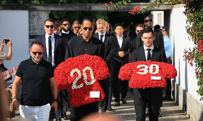 디오구 조타와 안드레 조타의 장례식에&nbsp; 버질 판데이크(왼쪽)과 안드레 로버트슨이&nbsp;두 형제의 이름과 등번호가 새겨진 붉은 유니폼 상의 모양의 조화를 들고 교회 안으로 들어가고 있다. 곤두마르=EPA연합뉴스
