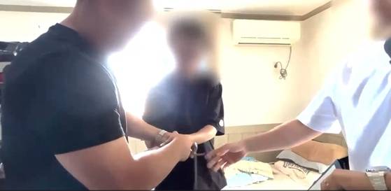 경찰이 16년 전 동거녀를 살해한 혐의로 50대 남성을 체포하고 있다. 경남경찰청 제공