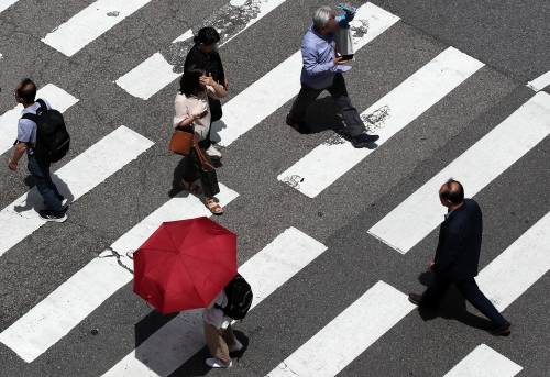 지난해 6월 서울 종로의 한 교차로 횡단보도에서 시민들이 양산과 손바닥으로 햇볕을 가린채 걷고 있다.   뉴스1