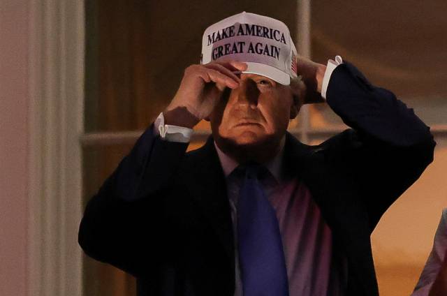 도널드 트럼프 미국 대통령이 4일(현지 시간) 워싱턴DC 백악관에서 열린 연례 독립기념일 불꽃놀이 행사를 관람하다가 모자를 고쳐 쓰고 있다. 로이터연합뉴스