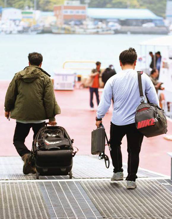 세월호 참사 발생 41일째인 2014년 5월26일 전남 진도 서망항에서 민간 잠수사들이 사고 해역으로 가기 위해 해경 경비정으로 향하고 있다. ⓒ연합뉴스