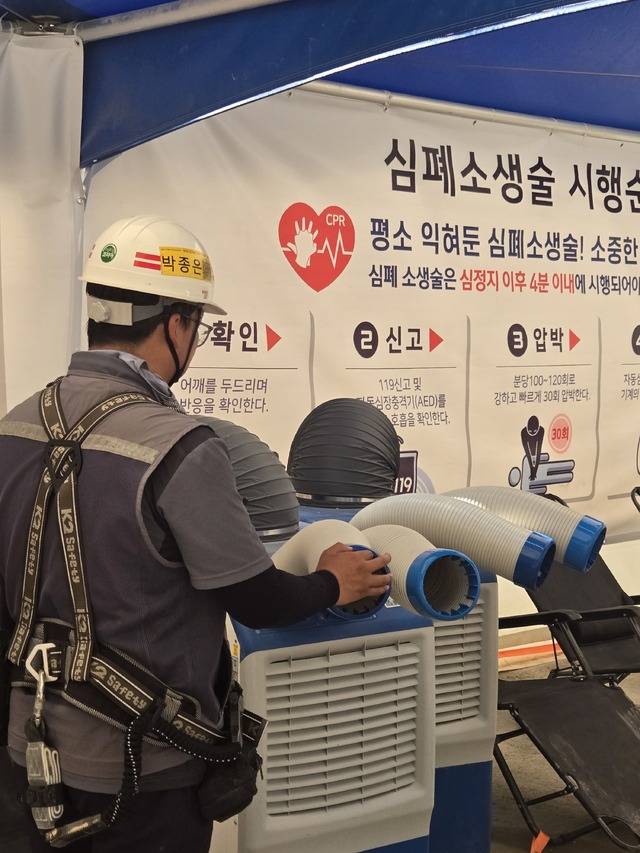 ▲ 작업자가 냉풍기 앞에서 잠시 쉬며 바람을 쐬고 있다./이형모 선임기자
