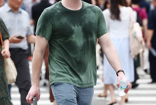 절기상 본격적인 더위가 시작된다는 소서(小暑)이자 서울 전역에 첫 폭염경보가 내려진 7일 서울 종로구 일대에서 한 시민이 땀에 젖은 채 걸어가고 있다./뉴스1