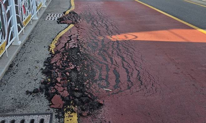 울산에서 11일째 폭염특보가 발령 중인 가운데 열기를 못 이긴 아스팔트 도로가 파손되는 사례가 잇따르고 있다. 사진은 최근 녹아내린 듯한 모양으로 파손된 울산 북구의 한 도로 아스팔트. 연합뉴스
