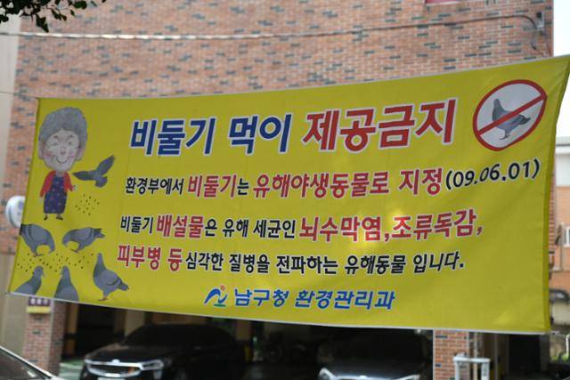 지난달 26일 울산 남구의 한 공원에 비둘기 먹이 주기를 금지하는 현수막이 걸려 있다. 울산=박은경 기자