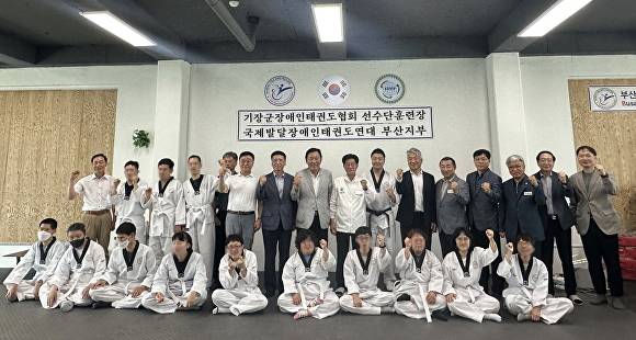 기장군장애인태권도협회 사무실 개소식과 현판식에서 주요 내빈들이 파이팅을 외치고 있다. [사진=부산광역시 기장군]