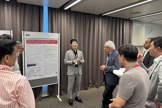 노영수(오른쪽 다섯 번째) 한미약품 ONCO임상팀 이사가 지난달 17일(현지시간) 스위스 루가노에서 열린 ‘국제림프종학회(ICML 2025)’에서 세계적 종양학자이자 ICML 학회장인 프랑코 카발리(오른쪽 네 번째) 박사를 비롯한 참석자들에게 ‘HM97662’의 연구 현황이 담긴 포스터 내용을 설명하고 있다.  [한미약품 제공]