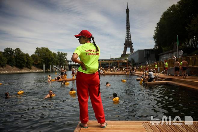 <font style="vertical-align: inherit;"><font style="vertical-align: inherit;">[파리=AP/뉴시스] 5일(현지 시간) 프랑스 파리 센 강에서 시민들이 수영을 하고 있는 가운데 안전요원이 배치돼 있다. 센 강은 100여 년 만에 공공 수영 공간으로 개방됐다. 마리 수로, 베르시 강변, 그르넬 항구 근처 등 세 곳이 야외 수영 구역으로 지정됐으며 오는 8월 31일까지 무료로 개방된다. 탈의실, 샤워 시설, 파라솔, 비치체어 등이 갖춰졌다. 2025.07.07.</font></font>