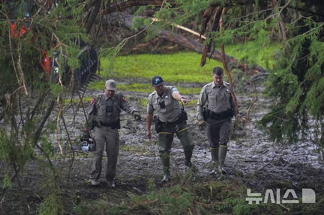 [헌트=AP/뉴시스] 6일(현지 시간) 미 텍사스주 헌트에서 경찰이 급류성 홍수가 휩쓸고 간 과달루페 강변의 기독교 청소년 캠프 '미스틱 야영장' 일대를 수색하고 있다. 텍사스주를 강타한 폭우와 홍수로 지금까지 사망자는 최소 80명, 실종자는 41명으로 늘어났다. 2025.07.07.
