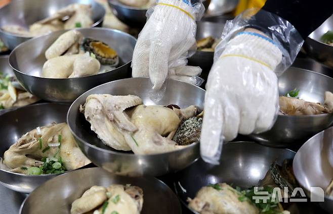 [대구=뉴시스] 이무열 기자 = 전국이 30도 안팎의 무더운 날씨를 보인 지난달 23일 대구 달서구노인종합복지관에서 열린 iM뱅크와 적십자가 함께하는 복(福) 삼계탕 나눔 행사에서 봉사원들이 삼계탕 배식을 준비하고 있다. 2025.06.23. lmy@newsis.com