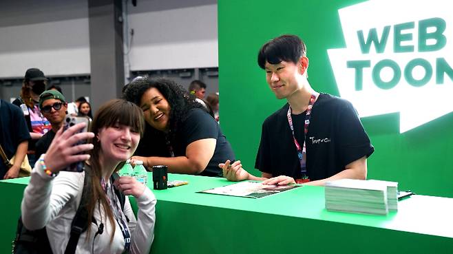 신의 탑' SIU 작가와 팬이 LA 애니메 엑스포 2025 사인회에서 기념사진을 촬영하고 있다. 네이버웹툰 제공