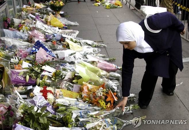 무슬림 여성이 킹스크로스역 앞에 헌화하고 있다 [EPA 연합뉴스]