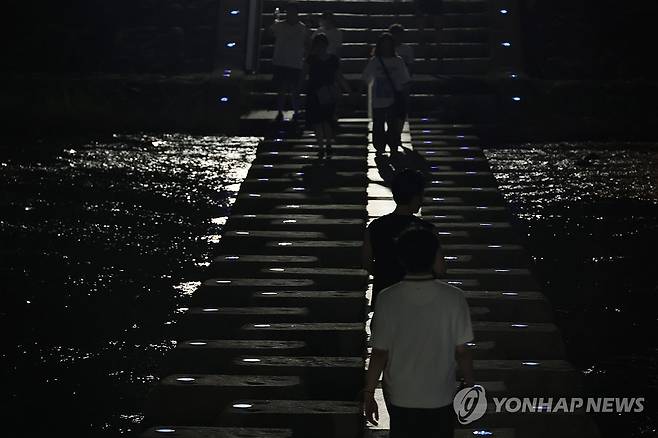 대구도 잠 못 드는 밤 (대구=연합뉴스) 박세진 기자 = 열대야가 이어진 7일 대구 신천에서 시민들이 산책하며 더위를 나고 있다. 2025.7.7 psjpsj@yna.co.kr