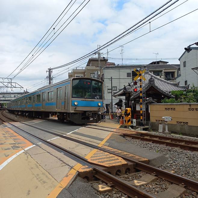 오사카 교외의 한적한 풍경 속을 지나는 일본 전철.