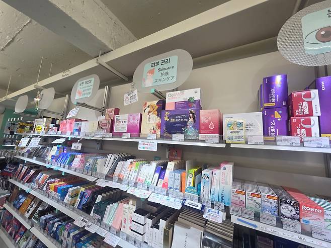 A display shelf is stocked with skincare products at a pharmacy near Hongdae Station in Seoul on July 1, 2025. Product descriptions are written in both English and Korean to accommodate foreign tourists./Choi Hyo-jung