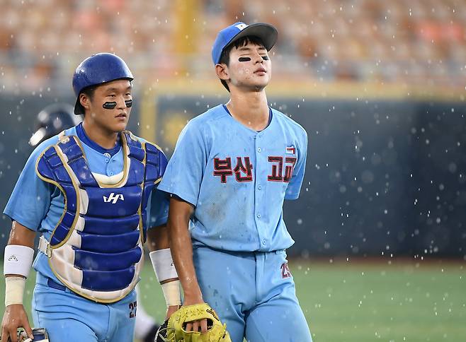 8일 서울 목동구장에서 열린 제80회 청룡기 고교야구선수권 대회 및 주말리그 왕중왕전 서울고와 부산고의 8강전. 2사 만루 상황 갑작스러운 폭우로 경기가 중단되자 부산고 투수 하현승(오른쪽)이 아쉬워하고 있다. /정재근 스포츠조선 기자