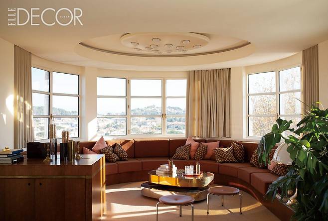 생트로페 언덕을 바라보는 거실은 배의 둥근 선체를 연상시킨다. 가에 아울렌티(Gae Aulenti)가 디자인한 아르테미데의 ‘알치노(Alcinoo)’ 테이블 램프, 가브리엘라 크레스피(Gabriella Crespi)의 ‘스쿨투라(Scultura)’ 로 테이블, 프리츠한센(Fritz Hansen)의 ‘PK33’ 스툴 등 아이코닉한 디자인의 가구들이 거실 풍경을 완성한다.