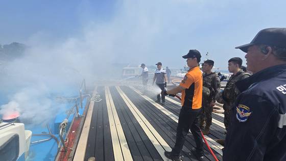 7일 오전 충남 태안군 영목항에서 열린 선박 화재 진압 훈련에서 119소방대와 해경이 호스를 이용해 불을 끄고 있다. 신진호 기자